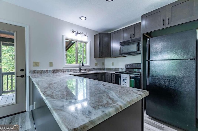 235 Red Bud Ln Unit 5, Hiawassee, GA 30546 - kitchen featuring black appliances, a sink, a peninsula, light stone countertops, and light wood-type flooring