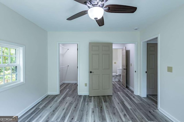 235 Red Bud Ln Unit 5, Hiawassee, GA 30546 - unfurnished bedroom with light wood-type flooring, baseboards, a walk in closet, a closet, and ceiling fan
