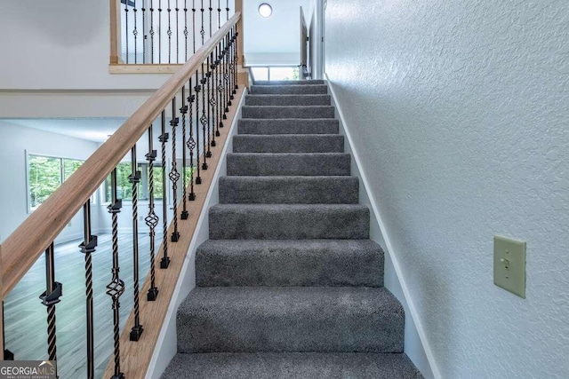 235 Red Bud Ln Unit 5, Hiawassee, GA 30546 - staircase with a textured wall, healthy amount of natural light, a high ceiling, and baseboards