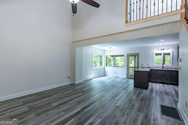 235 Red Bud Ln Unit 5, Hiawassee, GA 30546 - unfurnished living room featuring a ceiling fan, baseboards, a towering ceiling, and wood finished floors