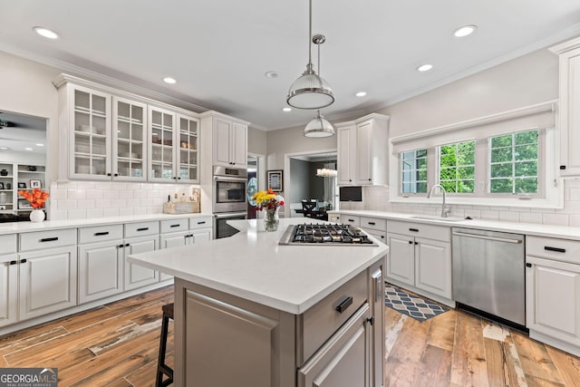 4030 River Ridge Chase Se, Marietta, GA 30067 - kitchen with stainless steel appliances, a sink, ornamental molding, light countertops, and light wood-style floors
