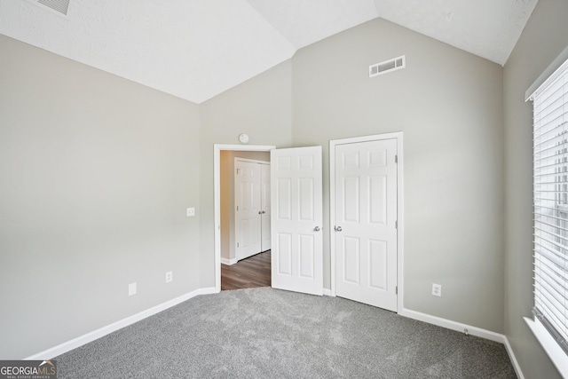 1147 Saint Phillips Ct, Locust Grove, GA 30248 - unfurnished bedroom featuring dark carpet, baseboards, multiple windows, and high vaulted ceiling