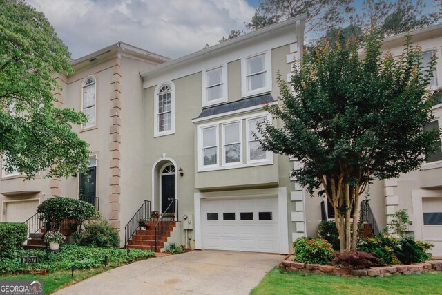 3697 E Bay St, Duluth, GA 30096 - townhome / multi-family property with a garage, stucco siding, and driveway