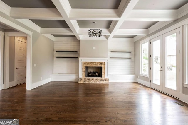 4821 Deer Creek Ct, Flowery Branch, GA 30542 - unfurnished living room with dark wood-style floors, beamed ceiling, a chandelier, a brick fireplace, and coffered ceiling