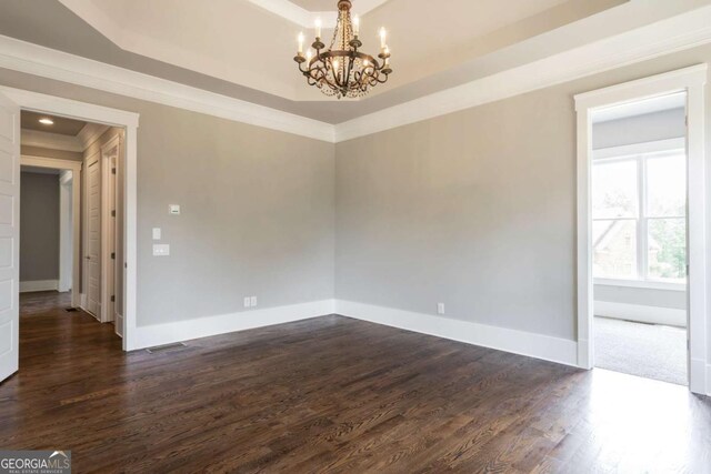 4821 Deer Creek Ct, Flowery Branch, GA 30542 - empty room with a tray ceiling, a chandelier, dark wood-type flooring, and ornamental molding