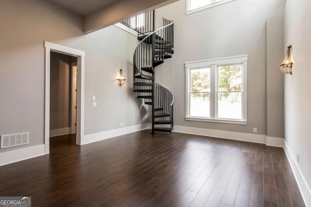 4821 Deer Creek Ct, Flowery Branch, GA 30542 - unfurnished living room featuring plenty of natural light, stairs, dark wood-style floors, and a high ceiling