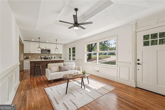 3422 Maplehurst Dr, Decatur, GA 30032 - living room with a tray ceiling, ceiling fan, a decorative wall, hardwood / wood-style floors, and a wainscoted wall