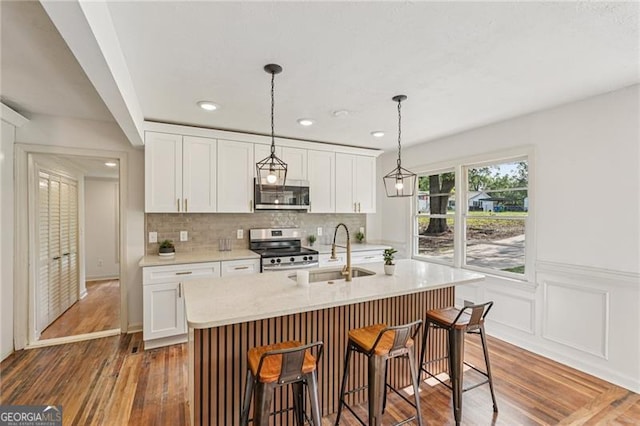 3422 Maplehurst Dr, Decatur, GA 30032 - kitchen featuring stainless steel appliances, a sink, white cabinetry, wainscoting, and recessed lighting