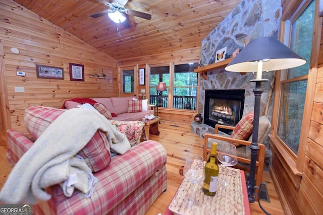 58 Hatchet Trl, Cherry Log, GA 30522 - living room with vaulted ceiling, wood finished floors, a ceiling fan, wooden walls, and a stone fireplace