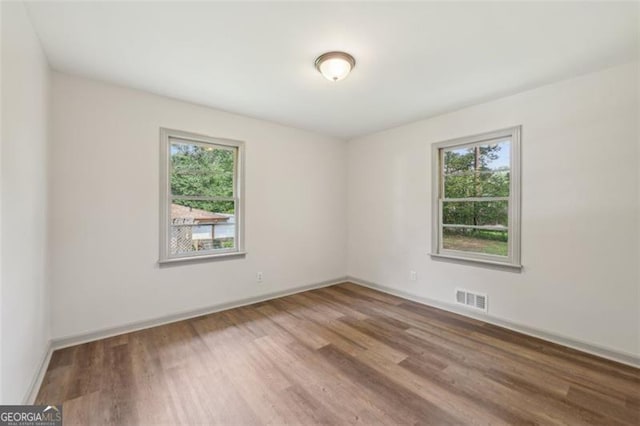 1261 Cliffwood Dr SE, Smyrna, GA 30080 - unfurnished room featuring plenty of natural light, wood finished floors, and baseboards