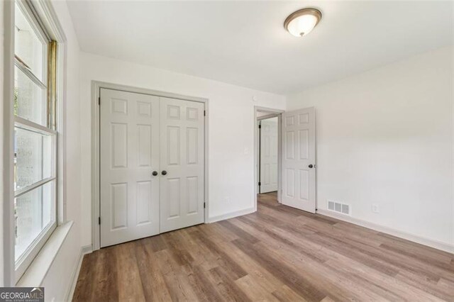 1261 Cliffwood Dr SE, Smyrna, GA 30080 - unfurnished bedroom with wood finished floors, a closet, and baseboards