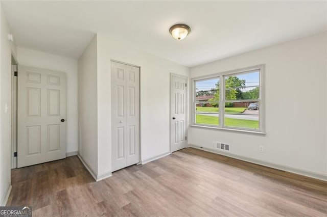 1261 Cliffwood Dr SE, Smyrna, GA 30080 - unfurnished bedroom with wood finished floors, baseboards, and two closets