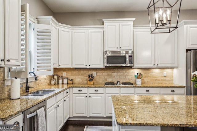 2579 Lulworth Ln, Marietta, GA 30062 - kitchen with appliances with stainless steel finishes, a sink, white cabinetry, decorative backsplash, and light stone countertops