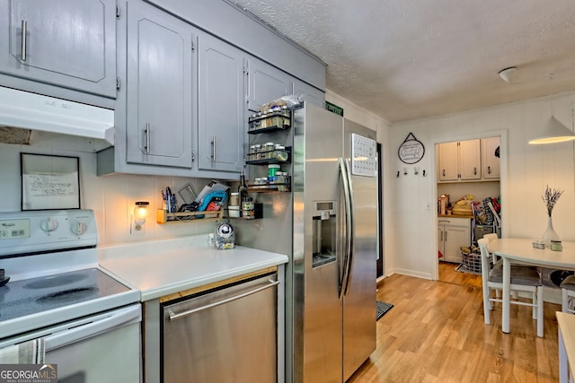 41 Mike Foster Ln, Clayton, GA 30525 - kitchen featuring appliances with stainless steel finishes, light wood-style floors, light countertops, under cabinet range hood, and a textured ceiling