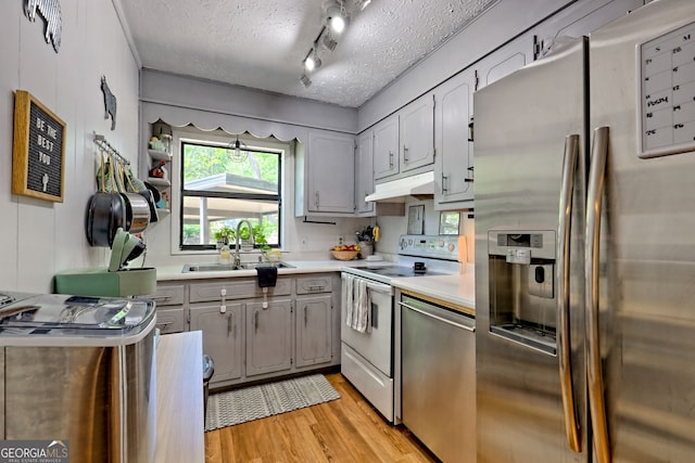 41 Mike Foster Ln, Clayton, GA 30525 - kitchen featuring appliances with stainless steel finishes, a sink, gray cabinets, light wood-type flooring, and a textured ceiling