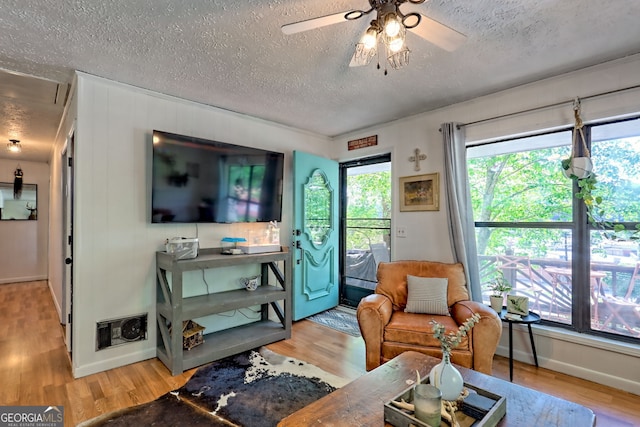41 Mike Foster Ln, Clayton, GA 30525 - living room with a textured ceiling, light wood-style floors, baseboards, and a ceiling fan