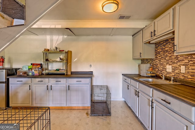 41 Mike Foster Ln, Clayton, GA 30525 - kitchen with a sink, dark countertops, freestanding refrigerator, decorative backsplash, and light tile patterned floors
