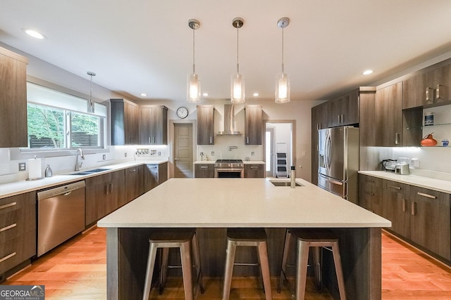 1267 Thomas Rd, Decatur, GA 30030 - kitchen featuring stainless steel appliances, a sink, wall chimney range hood, a kitchen island with sink, and a breakfast bar area