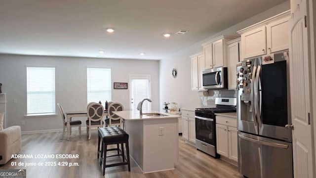 2757 Malton Way, Loganville, GA 30052 - kitchen featuring appliances with stainless steel finishes, a center island with sink, healthy amount of natural light, decorative backsplash, and recessed lighting