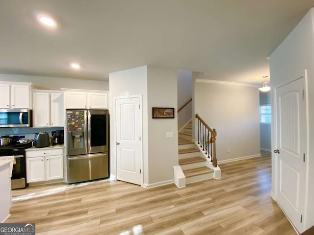 2757 Malton Way, Loganville, GA 30052 - kitchen with appliances with stainless steel finishes, white cabinetry, recessed lighting, light wood-style flooring, and crown molding