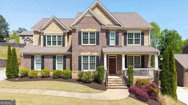 622 Rocky Creek Pt, Woodstock, GA 30188 - craftsman-style home with covered porch, brick siding, roof with shingles, and a front lawn
