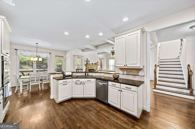 622 Rocky Creek Pt, Woodstock, GA 30188 - kitchen with stainless steel appliances, a sink, a peninsula, dark countertops, and dark wood finished floors