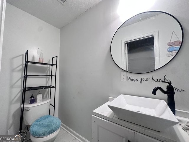 170 Graystone Cir, Macon, GA 31211 - bathroom featuring vanity, toilet, a textured ceiling, and baseboards