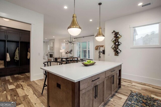 1168 Mado Loop, Chattahoochee Hills, GA 30268 - kitchen featuring a kitchen bar, light wood finished floors, baseboards, light countertops, and a center island