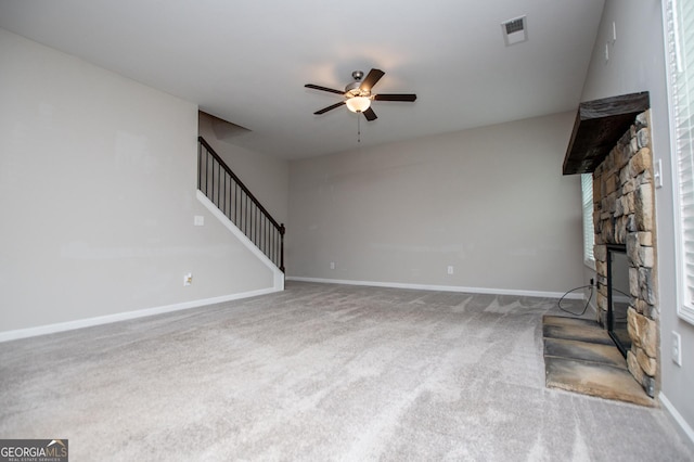309 Dean Ct, Temple, GA 30179 - unfurnished living room featuring ceiling fan, a stone fireplace, stairs, carpet flooring, and baseboards
