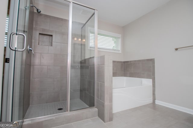 309 Dean Ct, Temple, GA 30179 - full bath featuring a garden tub, a stall shower, tile patterned flooring, and baseboards