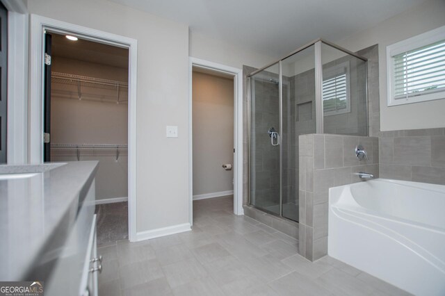 309 Dean Ct, Temple, GA 30179 - bathroom with a stall shower, a garden tub, a spacious closet, baseboards, and vanity