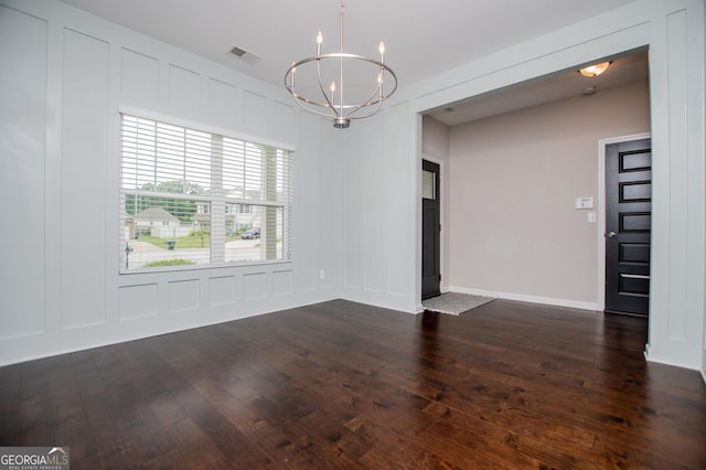 309 Dean Ct, Temple, GA 30179 - empty room with a chandelier, dark wood-style flooring, a decorative wall, and baseboards
