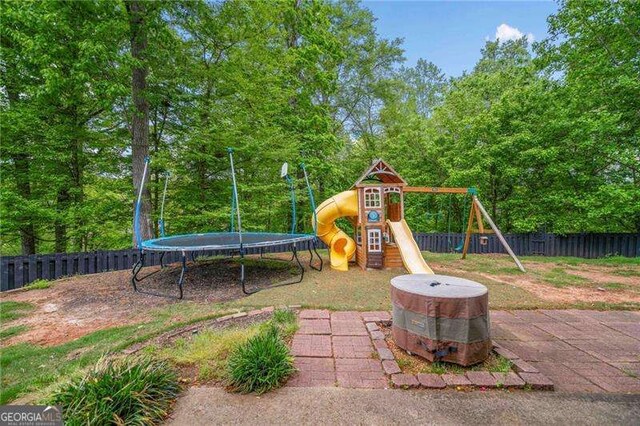 1039 Avery Creek Dr, Woodstock, GA 30188 - fenced backyard with a playground and a trampoline