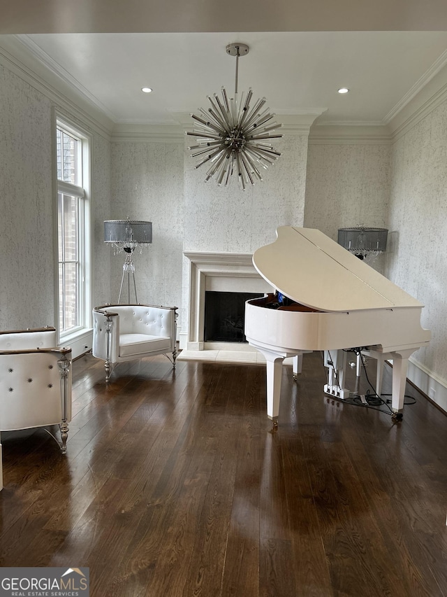 3084 Watsons Bnd, Milton, GA 30004 - dining room featuring wood-type flooring, ornamental molding, a chandelier, a fireplace with raised hearth, and wallpapered walls