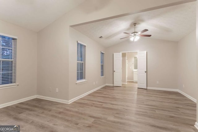 7113 Ambercrest Ct, Austell, GA 30168 - unfurnished room with vaulted ceiling, a ceiling fan, and wood finished floors