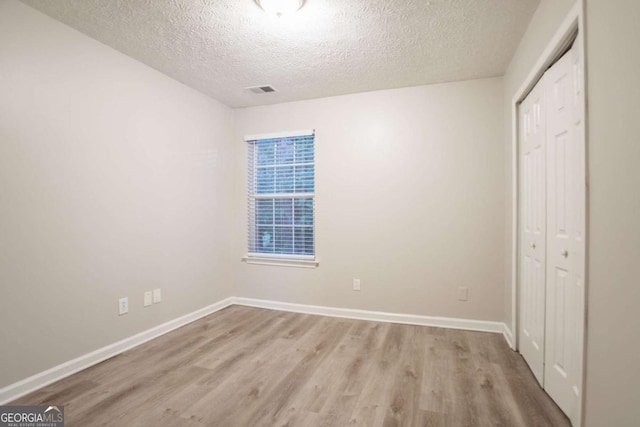 7113 Ambercrest Ct, Austell, GA 30168 - unfurnished bedroom featuring a closet, light wood finished floors, and a textured ceiling