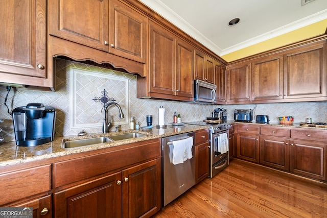 745 Chickasaw Trl S, Sparta, GA 31087 - kitchen featuring stainless steel appliances, a sink, light stone counters, wood finished floors, and crown molding