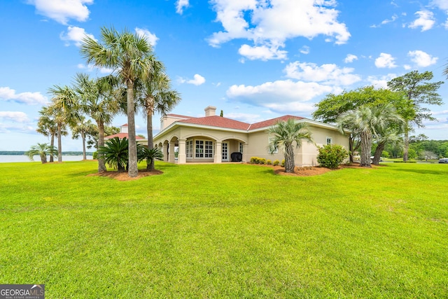 745 Chickasaw Trl S, Sparta, GA 31087 - back of property with a lawn, a water view, a chimney, and stucco siding