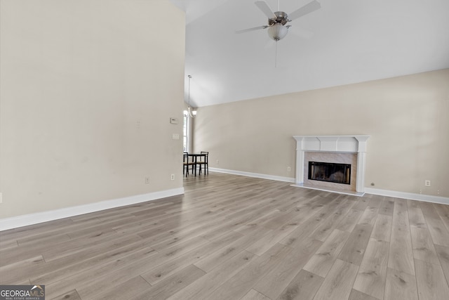 2140 Wildcat Cliffs Way, Lawrenceville, GA 30043 - unfurnished living room with a ceiling fan, high vaulted ceiling, light wood finished floors, and a premium fireplace