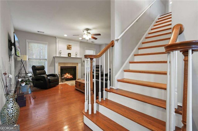 3224 Wolf Club Ln SW, Atlanta, GA 30349 - staircase with a ceiling fan, wood-type flooring, a lit fireplace, and recessed lighting