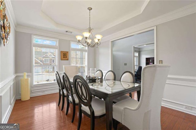 3224 Wolf Club Ln SW, Atlanta, GA 30349 - dining area with a chandelier, a raised ceiling, hardwood / wood-style floors, wainscoting, and a decorative wall