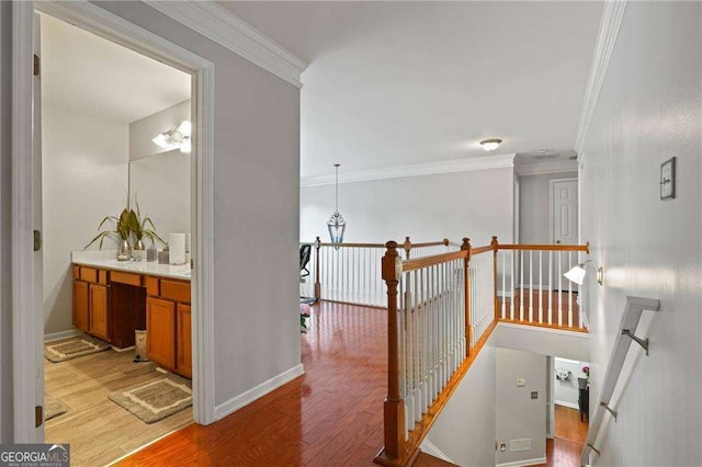 3224 Wolf Club Ln SW, Atlanta, GA 30349 - corridor with an upstairs landing, light wood-style flooring, crown molding, baseboards, and a chandelier