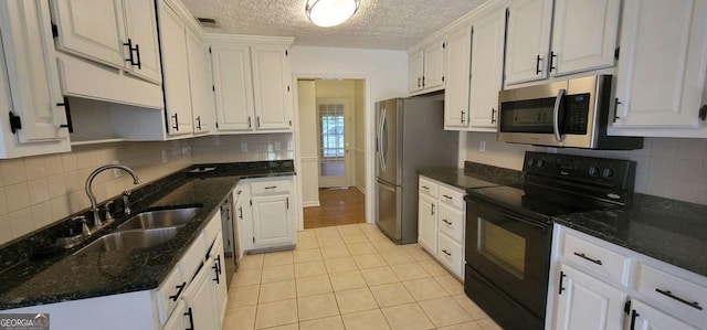 1934 Mcconnell Rd, Grayson, GA 30017 - kitchen with stainless steel appliances, white cabinetry, light tile patterned flooring, decorative backsplash, and a textured ceiling