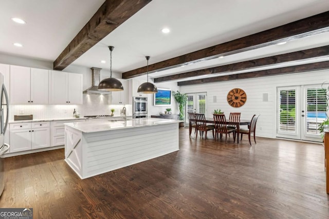5860 Riverwood Dr, Sandy Springs, GA 30328 - kitchen with wall chimney exhaust hood, healthy amount of natural light, french doors, white cabinets, and beam ceiling