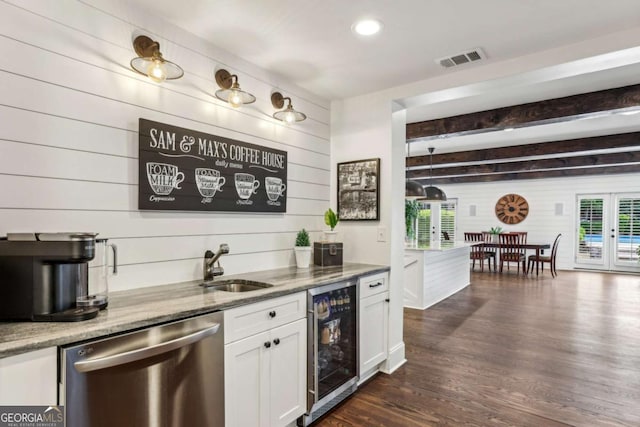 5860 Riverwood Dr, Sandy Springs, GA 30328 - bar featuring stainless steel dishwasher, beverage cooler, wooden walls, plenty of natural light, and dark wood-style flooring