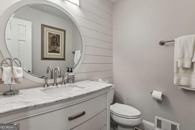5860 Riverwood Dr, Sandy Springs, GA 30328 - half bath with vanity, toilet, and wood walls