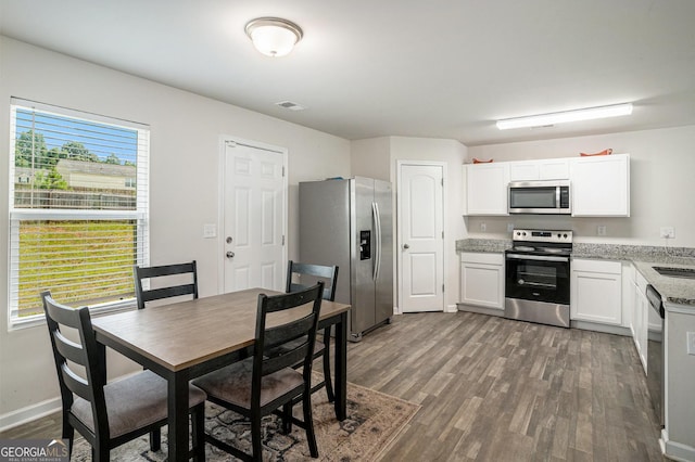 1776 Cheryl Ave, Griffin, GA 30224 - kitchen featuring stainless steel appliances, dark wood-type flooring, white cabinets, and light stone counters