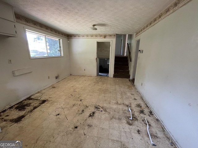 8423 Avalon Dr, Riverdale, GA 30274 - unfurnished living room with a textured ceiling and stairs