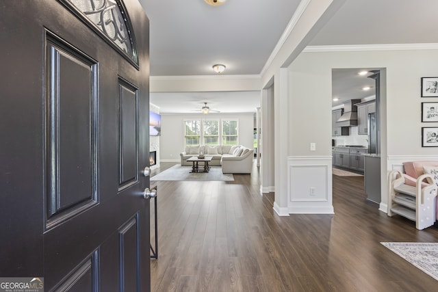 830 Tom Miller Rd, Bethlehem, GA 30620 - entrance foyer with ornamental molding, dark wood-style floors, a fireplace, ceiling fan, and baseboards