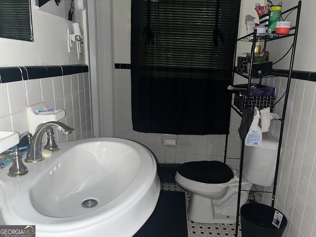 2526 Kensington Rd, Macon, GA 31211 - bathroom with tile walls, toilet, a sink, and wainscoting
